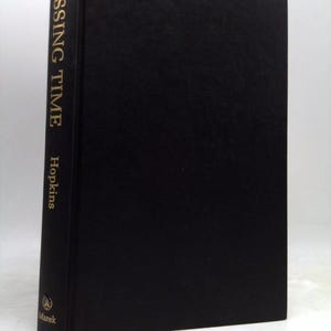 May include: A hardcover book titled "Missing Time" by Hopkins. The book has a black cover with gold lettering on the spine. The publisher's logo is visible at the bottom of the spine.