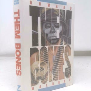 May include: A hardcover book titled "THEM BONES" by Howard Waldrop. The cover features a soldier with skull-like face paint and the word "THEM" in large, bold letters. The spine displays the title and author's name.