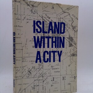 May include: A vintage book cover with a black and white map and the title "Island Within A City" in blue text.