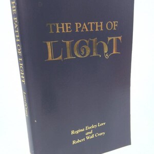 May include: A navy blue hardcover book titled "The Path of Light" by Regina Eveley Lorr and Robert Wall Crary. The title is in gold lettering.