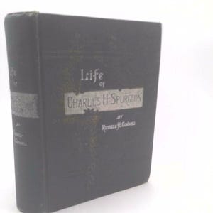 May include: A gray hardcover book with the title "Life of Charles H. Spurgeon" by Russell H. Conwell.