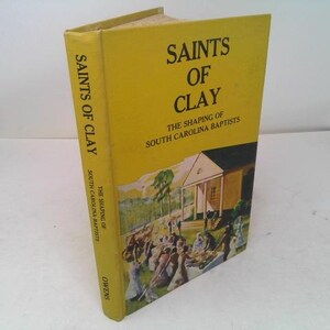 May include: A hardcover book titled "Saints of Clay" with a yellow cover. The book's spine and cover feature the title and subtitle, "The Shaping of South Carolina Baptists." The cover illustration depicts a church and people.
