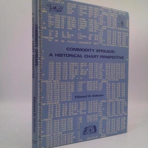 May include: A blue book with the title "Commodity Spreads: A Historical Chart Perspective" by Edward D. Dobson. The book cover features a chart with commodity prices and dates.