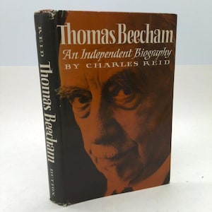May include: A hardcover book titled "Thomas Beecham: An Independent Biography" by Charles Reid. The book has a portrait of a man on the cover in shades of orange and brown. The spine is black with the author's name and publisher.