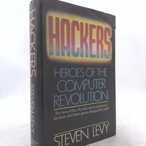 May include: A hardcover book titled "Hackers: Heroes of the Computer Revolution" by Steven Levy. The cover is black with the title in large, colorful letters. The book's spine also displays the title and author's name.