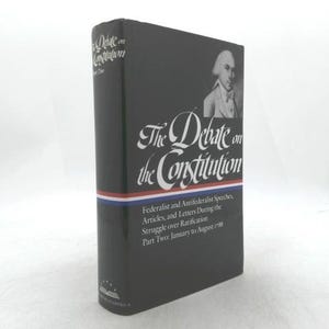 May include: A hardcover book titled "The Debate on the Constitution" in black with white and red accents. The book features a portrait of a man in a white wig and a bow tie. The text includes "Federalist and Antifederalist Speeches, Articles, and Letters During the Struggle over Ratification."