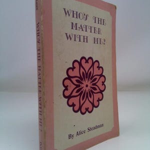 May include: A vintage book titled "WHO'S THE MATTER WITH ME?" by Alice Steadman. The book cover is a light pink with a darker pink border and a floral design. The title is in dark purple, and the book is slightly worn.