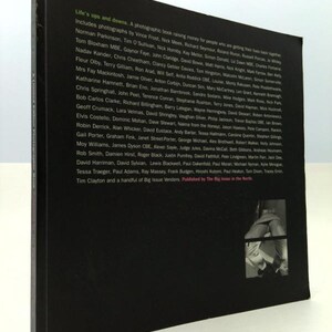 May include: A black and white photo book titled "Life's Ups and Downs." The book features a list of names of photographers and contributors. The book is about raising money for people who are getting their lives back together.