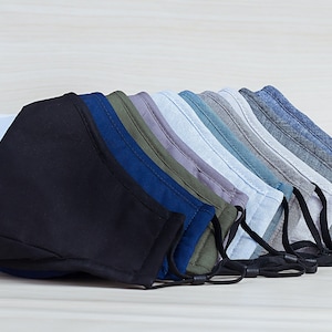 May include: A set of ten face masks in various shades of blue, gray, and green. The masks are made of a soft, breathable fabric and have adjustable ear loops.