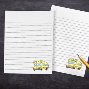 May include: Two sheets of lined paper with a yellow school bus illustration at the bottom of each sheet. The bus has the word "BUS" written on the side.