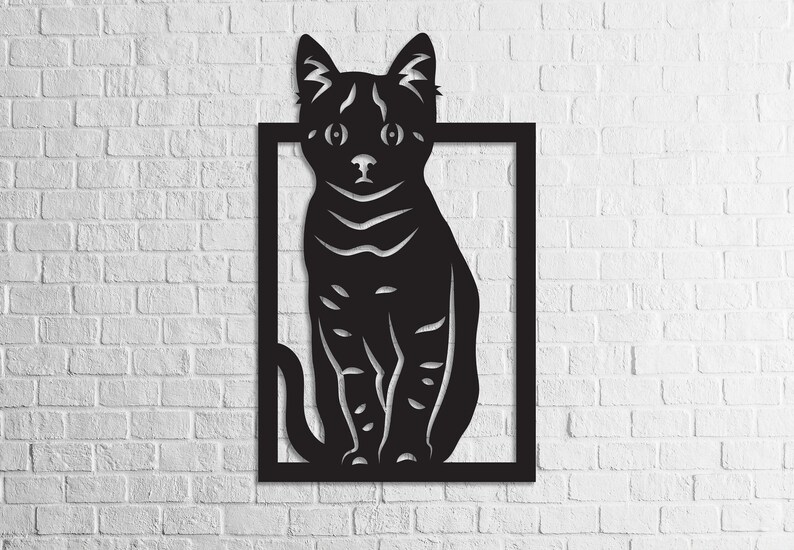 以下が含まれることがあります： 正方形のフレームの中に座っている猫のシルエットが描かれた黒い金属製の壁飾り。猫は正面を向いており、耳はピンと立っていて、尻尾は体の周りに巻かれている。