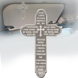 May include: A silver-toned metal cross ornament featuring engraved text that reads: Dear Lord, please protect me, my passengers, and all those the way. Guide my mind, and eyes alert. Watch over each mile I travel. Lead me through the unknown, and bring us safely home. Amen.