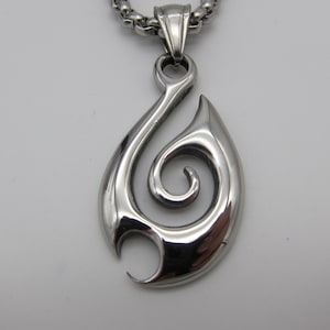 May include: A silver chain necklace with a pendant featuring a stylized swirl design.