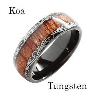 May include: A black tungsten ring with a Koa wood inlay and a silver engraved floral design. The ring is labeled "Koa" and "Tungsten".