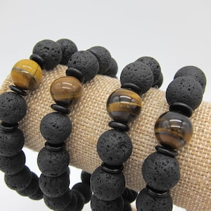 May include: Three bracelets with black lava rock beads and tiger's eye beads.