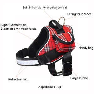 May include: Red and black tartan dog harness with a built-in handle, a D-ring for leads, a small pouch, and reflective trim. The harness has an adjustable strap and a large buckle.