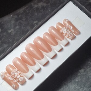 French tips bianche con fiori bianchi 3d. Unghie finte, finitura lucida, unghie finte, quadrate, riutilizzabili