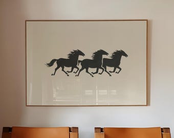 May include: Interior shot featuring two wooden armchairs with tan leather seats. Above them hangs a framed print with a silhouette of three running horses. A glass coffee table and a black and white checkered floor complete the scene.