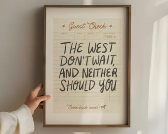 May include: A framed print with a vintage guest check design. The text reads "The West Don't Wait, And Neither Should You."  The print has a brown wooden frame and a white background.