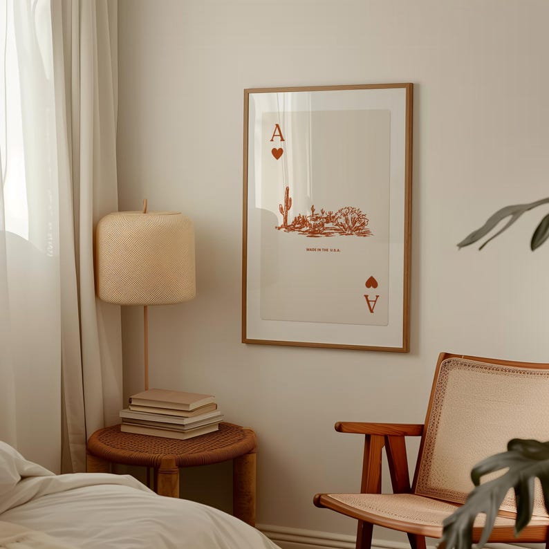 May include: A framed print of an ace of spades playing card with a desert landscape illustration in orange. The card reads "Made in the U.S.A."