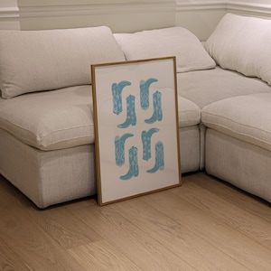 May include: A framed print with a white background and a pattern of blue cowboy boots. The boots are arranged in a grid pattern.