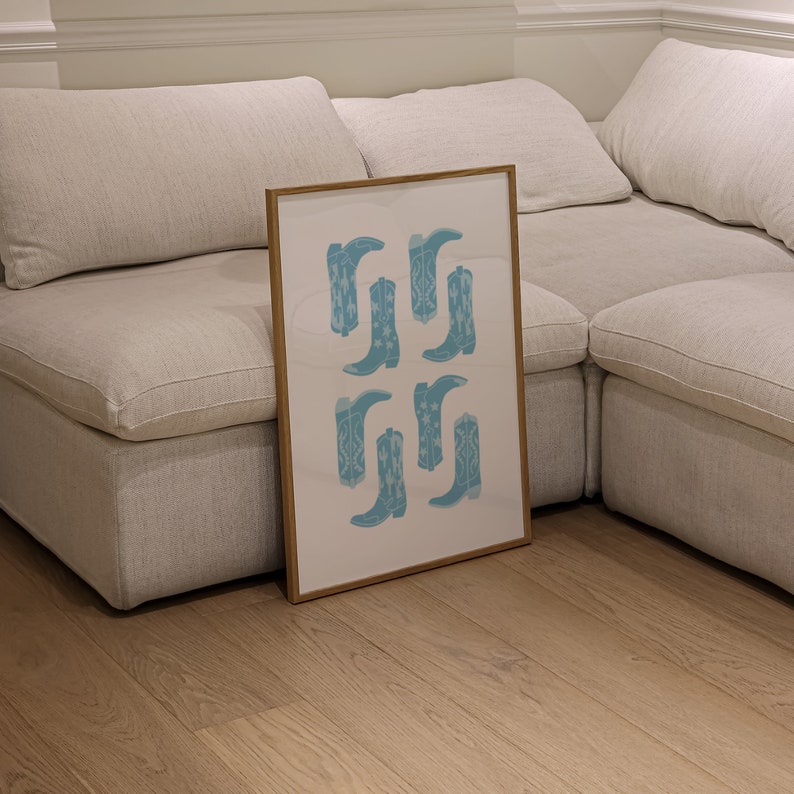May include: A framed print with a white background and a pattern of blue cowboy boots. The boots are arranged in a grid pattern.