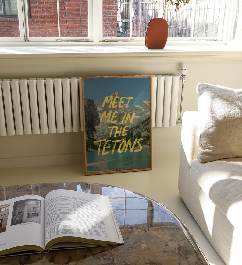 May include: A framed print with a mountain scene and the text "Meet me in the Tetons" in gold lettering.