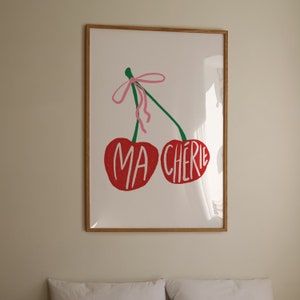 May include: A framed print of two red cherries with a pink ribbon and the text "MA CHERIE" in green letters.