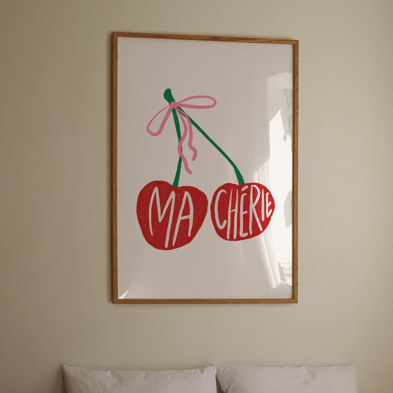 May include: A framed print of two red cherries with a pink ribbon and the text "MA CHERIE" in green letters.