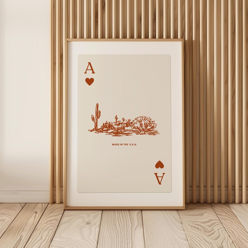 May include: A framed print of an ace of spades playing card with a desert landscape illustration. The card is red and the text "MADE IN THE U.S.A." is printed below the illustration.