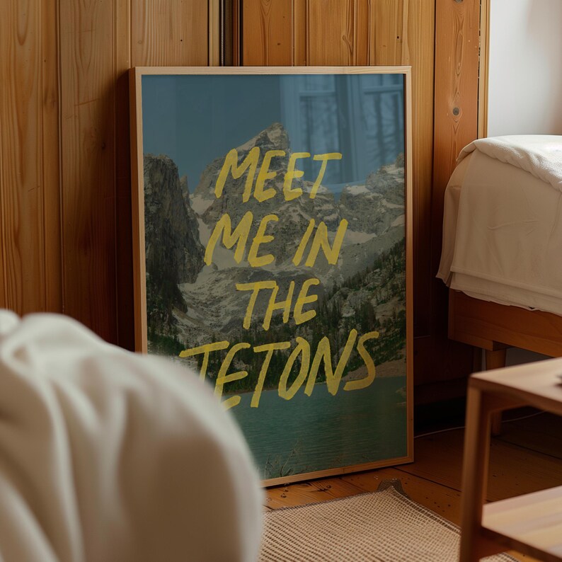 May include: A framed print with a mountain landscape and the text "MEET ME IN THE TETONS" in yellow lettering.