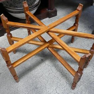 May include: A wooden table base with a starburst design. The base is made of light brown wood and has a rustic look.