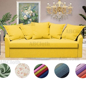 May include: A yellow fabric sofa with three pillows. The sofa has a tufted back and a wooden frame. The sofa is in front of a wall with a painting and a chandelier. The sofa is surrounded by a variety of fabric swatches in different colors and patterns.