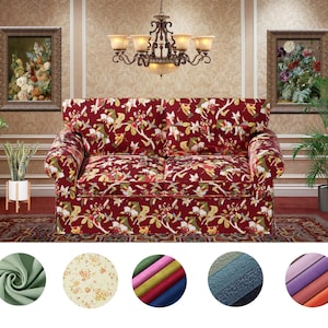 以下が含まれることがあります： 木製のフレームに赤い花柄のソファ。ソファは、ラグ、植物、壁にアートワークのあるリビングルームにあります。