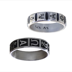 May include: Two silver rings with black enamel. The top ring has the words "SV 925", "A", "IHS", and a fish symbol. The bottom ring has the letters "A", "U", and a cross symbol.