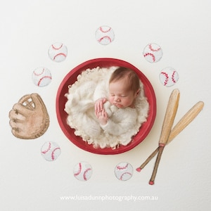 May include: A newborn baby peacefully sleeps in a red bowl filled with white fluff, surrounded by baseball-themed illustrations. The image includes baseballs, a glove, and two bats, creating a sports-themed newborn photo.