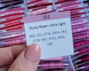 May include: A close-up of a pink and white label with the text "151 Dusty Rose- Ultra Light" and a list of DMC floss numbers: 963, 151, 3716, 3354, 962, 3733, 961, 3731, 3350, 150.