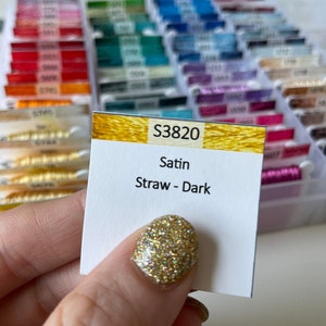May include: A close-up of a spool of embroidery floss labeled "S3820 Satin Straw - Dark".