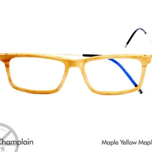 K&ouml;nnte beinhalten: Holzbrille mit einem Ahornholzrahmen und blauen B&uuml;geln. Der Rahmen ist hellbraun und die B&uuml;gel sind dunkelblau. Die Brille hei&szlig;t "Champlain" und ist aus "Maple Yellow Maple" gefertigt.