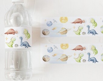 May include: Two sheets of water bottle labels with a space theme. The labels feature dinosaurs, planets, stars, and rockets. The labels are printed on white paper with a blue background.