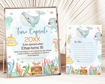 Può includere: Una carta di capsula del tempo blu e bianca con illustrazioni di balena, polpo e cavalluccio marino. La carta dice "Capsula del tempo 20XX Da aprire quando Ethan compie 18 anni".