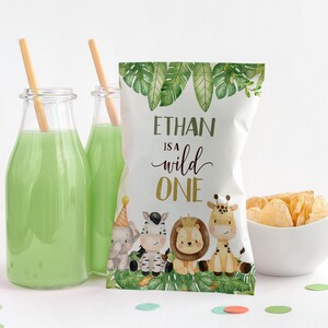 Könnte beinhalten: Ein weißer Chip-Beutel mit grünem Dschungel-Motiv. Der Beutel trägt eine goldene Aufschrift mit dem Text "Ethan is a wild one". Der Beutel ist mit Comic-Tieren verziert, darunter ein Zebra, eine Giraffe, ein Löwe und ein Elefant.