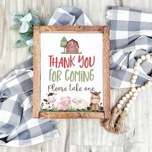May include: A framed sign with a red barn and farm animals, saying "Thank You For Coming. Please take one."