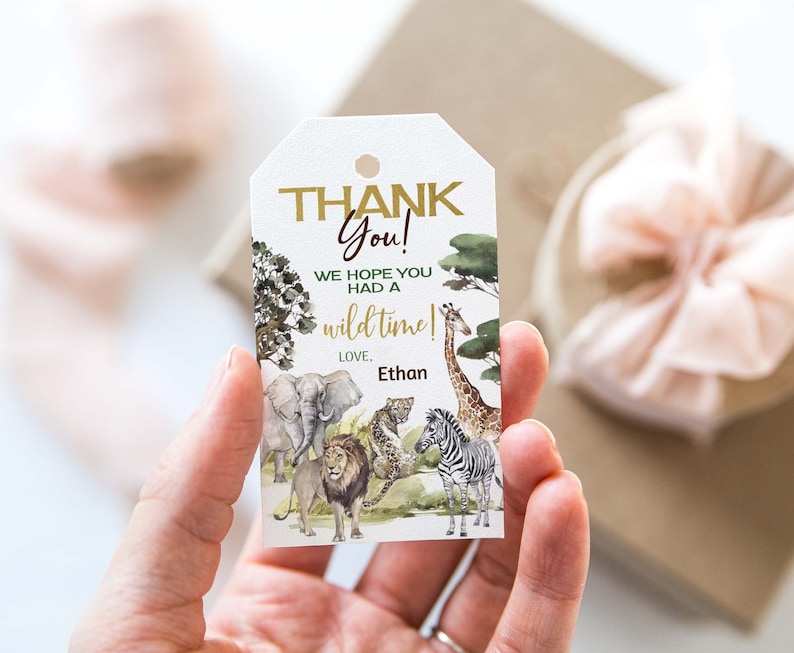 May include: Thank you tag with a jungle theme. It features a giraffe, zebra, lion, elephant, and leopard. The text reads "Thank You! We hope you had a wild time! Love, Ethan".