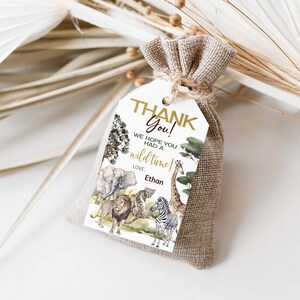 May include: A white thank you tag with a gold border and the text "Thank You! We hope you had a wild time! Love, Ethan". The tag features a watercolor illustration of a jungle scene with animals like a lion, giraffe, zebra, and elephant.