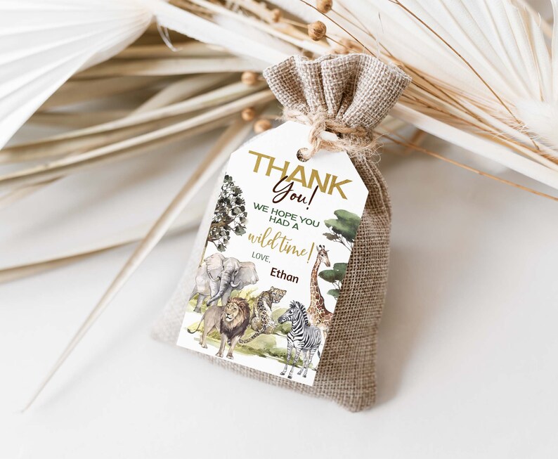 May include: A white thank you tag with a gold border and the text "Thank You! We hope you had a wild time! Love, Ethan". The tag features a watercolor illustration of a jungle scene with animals like a lion, giraffe, zebra, and elephant.