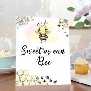 Puede incluir: Un cartel blanco con una linda ilustración de abeja de dibujos animados y el texto "Sweet as can Bee". El cartel está decorado con panales de abeja amarillos y pequeñas abejas.