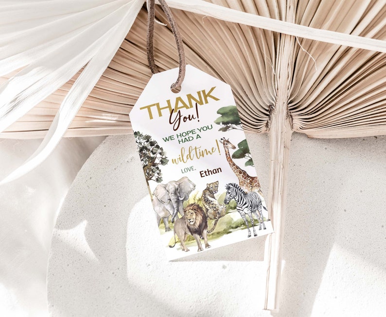 May include: Thank You! We hope you had a wild time! Love, Ethan. A white thank you tag with gold lettering and a jungle animal illustration.