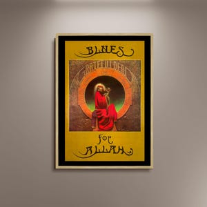 May include: A framed poster with a yellow background and black border. The poster features the words "BLUES" and "for Allah" in stylized script. The central image is a figure in red robes playing a stringed instrument.