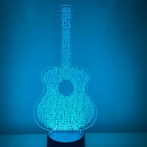 May include: A blue light-up guitar shaped nightlight with the lyrics to the song "See the Stone Set" by the band "Of Monsters and Men" printed on it.